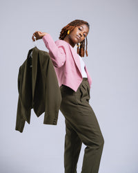 Woman holding a green jacket against a gray background