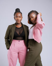 Two women posing together against a plain background