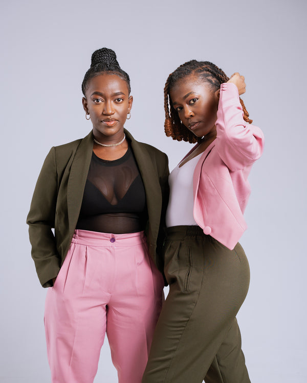 Two women posing together against a plain background